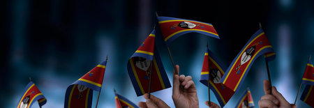 Swaziland flags in their hands on a blurred urban backgroundの写真素材