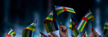 Central African Republic flags in their hands on a blurred urban backgroundの写真素材