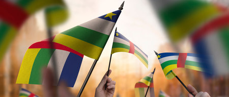 Central African Republic flags in their hands on a blurred urban backgroundの写真素材