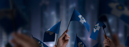 CIS flags in their hands on a blurred urban background