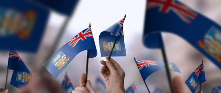 Falkland Islands flags in their hands on a blurred urban backgroundの写真素材