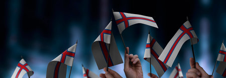 Faroe Islands flags in their hands on a blurred urban backgroundの写真素材