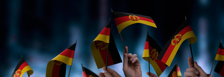 GDR flags in their hands on a blurred urban backgroundの写真素材