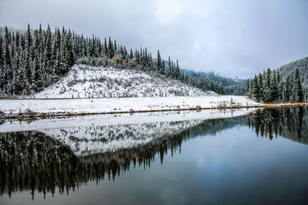 Fall colours and early snow on the lake, Sibbald Lake Provincial Recreation Areaの写真素材