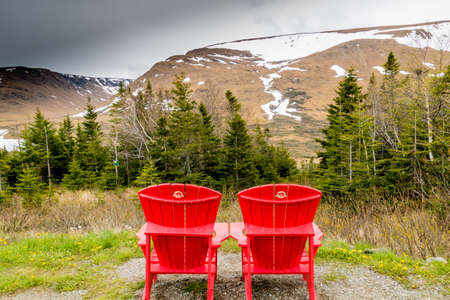Red chairs over looking the Table lands. Gros Morne National Park, Newfoundland, Canadaの写真素材