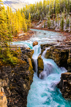 Large boulder stands in the way of water rushing over the Sumwapta Falls. Yoho National Park, Alberta, Canadaの写真素材