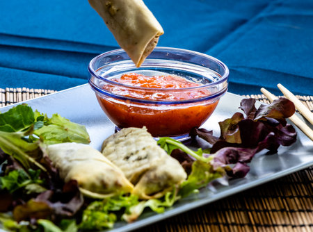 Dipping a sping roll into sweet chilli sauce. Calgary, alberta, Canada