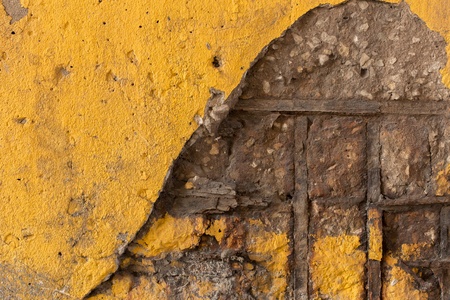 Yellow concrete divider wall cracking to reveal metal rodsの写真素材