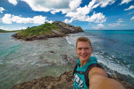 Handsome tourist takes travel selfie at the islandの写真素材