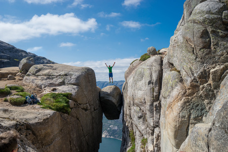 Man jumping over Kjeragbolten in Norway. Kjeragの写真素材