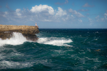 Girl standing on the edge of Devils Bridge bay - Caribbean tropical sea - Antigua and Barbuda. Concept of freedom an powerの写真素材