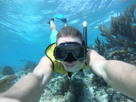 Underwater wide angle selfie of swimmer in a crystal water with marina lifeの写真素材