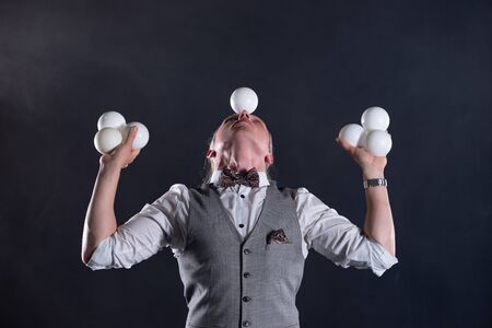 Juggler wearing a suit like a businessman with white balls. concept of success and managementの写真素材