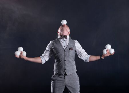 Juggler wearing a suit like a businessman with white balls. concept of success and managementの写真素材