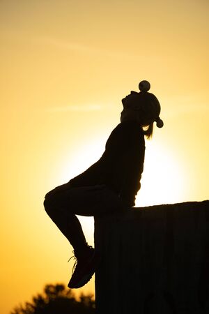 Silhouette of juggler with balls on colorful sunsetの写真素材