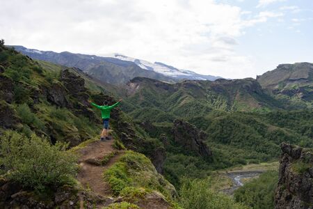 Man hiker on a top of a green mountainの写真素材
