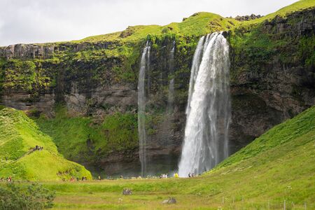 South Region, Iceland - July 29, 2019 - Tourists visiting the beautiful waterfall of Seljalandsfoss in the summerのeditorial素材