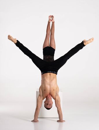 Duo Of Acrobats Showing hand to hand Trick, Isolated On White