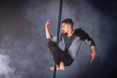 Performance concept. Man hanging on chinese pole. Athlete performing flying poleの写真素材