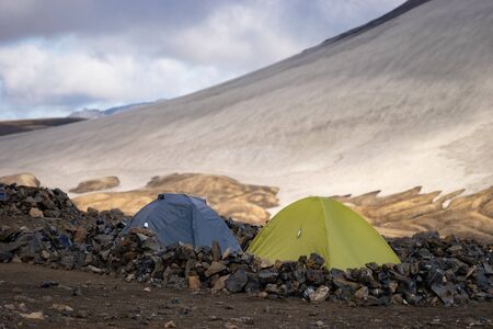 Camping with tents. Snowy mountain glaciers and storm wind. Iceland.の写真素材