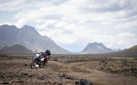 Two enduro Motorcycle standing on a dirt road in the desert surrounded by mountains on the...