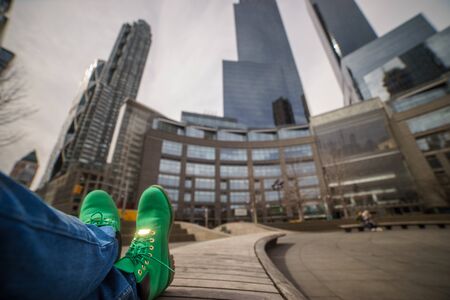 Traveling concept. Green boots close up with blurred new york city on background