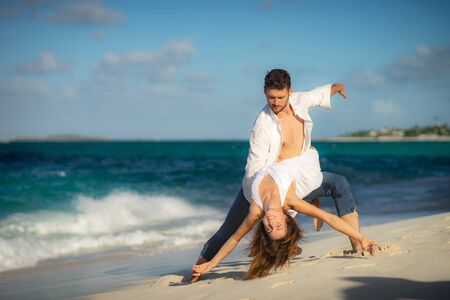 loving couple dancing at sand on sea beach at summer against waves surfの写真素材