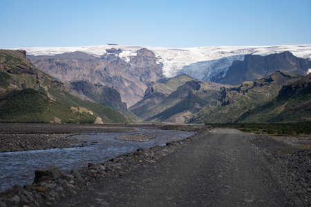 Scenic view Of Mountain Road Among Snowy Mountains nearby river in Thorsmork, Icelandの写真素材