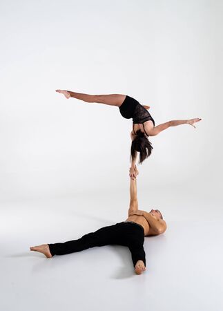 Duo Of Acrobats Showing hand to hand Trick, Isolated On Whiteの写真素材