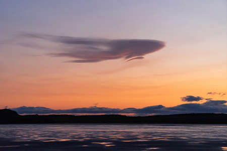 Beautiful sunset on the sea with very unusual shaped cloudの写真素材