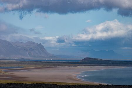 Icelandic landscape with mountains, blue sky and green grass on the foreground. West fjord part.
