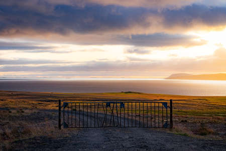 A Misty Landscape with Gate and dramatic cloudscape during Sunset. Concept of passing to heavenの写真素材