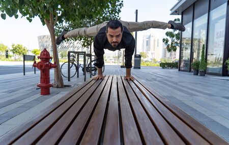Acrobat keep balance one the hands on the street. Concept of modern, business and unlimited...