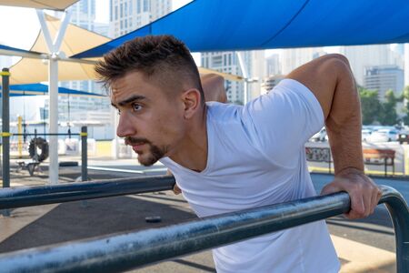 Muscular man doing workout on the street in Dubai. Concept of healthy lifestyle