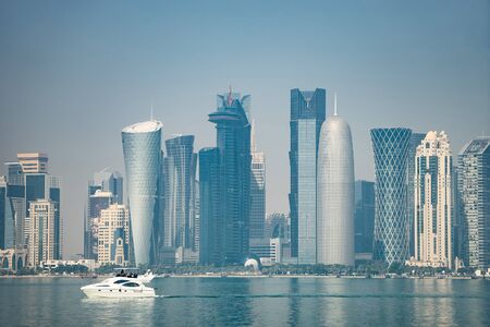 Panoramic view of modern skyline of Doha with boat foreground. Concept of wealth and luxury.