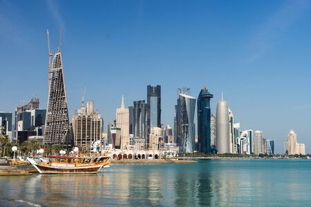 Skyscrapers in the city center with water and boat foreground of Doha, Qatar 2020の写真素材