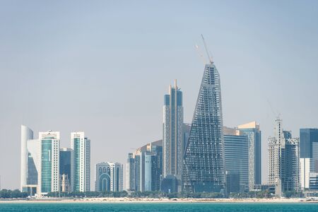 Panoramic view of modern skyline of Doha through the blue water. Concept of wealth and luxury.の写真素材