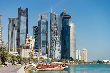 Skyscrapers in the city center with water and boat foreground of Doha, Qatar 2020の写真素材