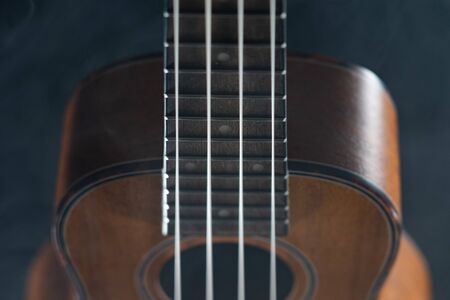 Hawaii ukulele guitar isolated against black background with smokeの写真素材