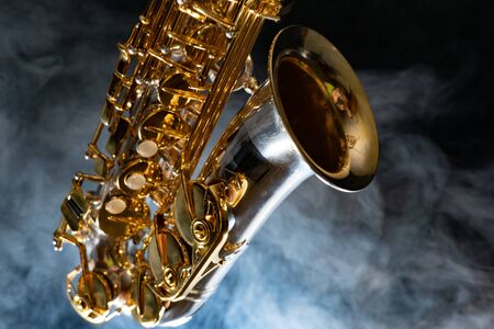 Golden shiny alto saxophone on black background with smoke. copy spaceの写真素材