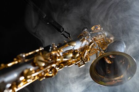 Golden shiny alto saxophone on black background with smoke. copy spaceの写真素材