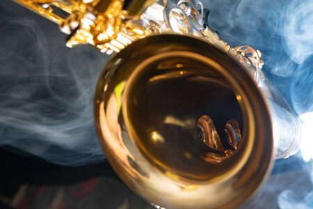 Golden shiny alto saxophone on black background with smoke. copy spaceの写真素材