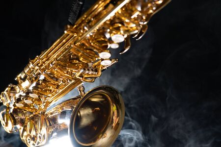 Golden shiny alto saxophone on black background with smoke. copy spaceの写真素材