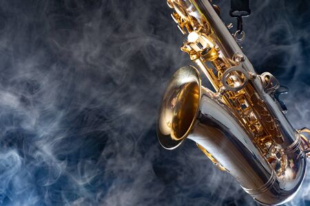 Golden shiny alto saxophone on black background with smoke. copy spaceの写真素材