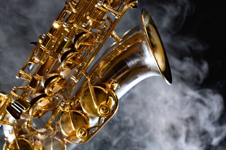 Golden shiny alto saxophone on black background with smoke. copy spaceの写真素材