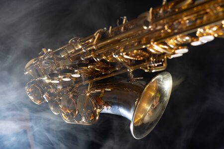 Golden shiny alto saxophone on black background with smoke. copy spaceの写真素材