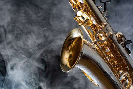 Golden shiny alto saxophone on black background with smoke. copy spaceの写真素材