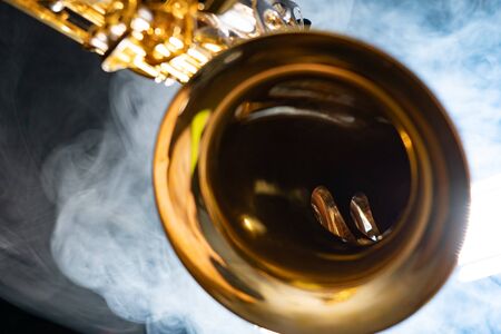 Golden shiny alto saxophone on black background with smoke. copy spaceの写真素材