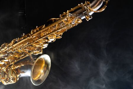 Golden shiny alto saxophone on black background with smoke. copy spaceの写真素材