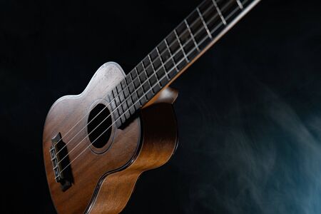 Hawaii ukulele guitar isolated against black background with smoke